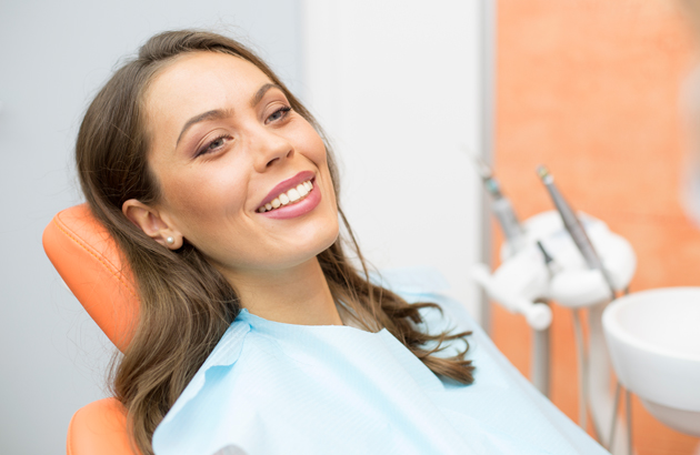 Smiling woman in dental chair at Sunridge Dental Care office during treatment.