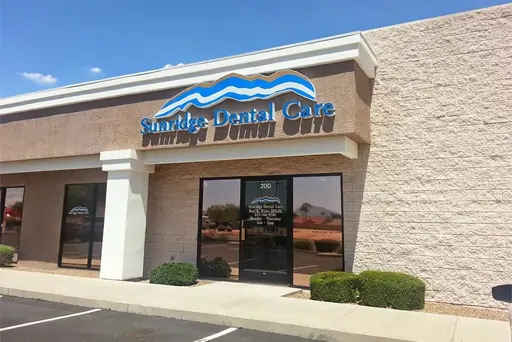 Sunridge Dental Care storefront exterior with brick facade, glass doors, and signage in daylight.