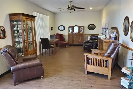 Spacious dental office waiting room with comfortable seating, wooden furniture, and professional décor.