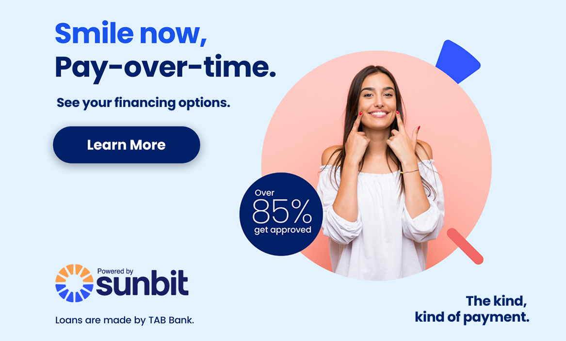 Woman in white coat holding credit card with Sunbit payment option displayed for dental financing.